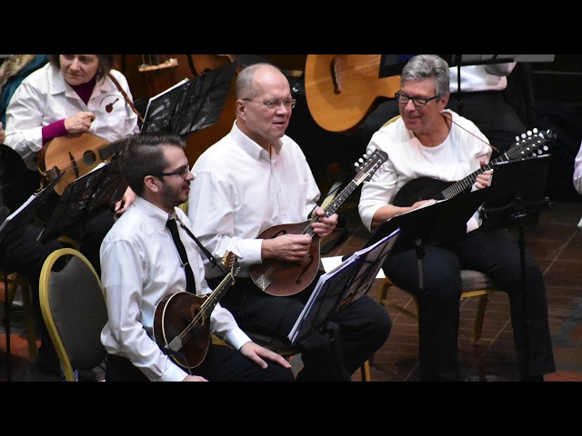 Three mandolin players chatting in their seats prior to a performance