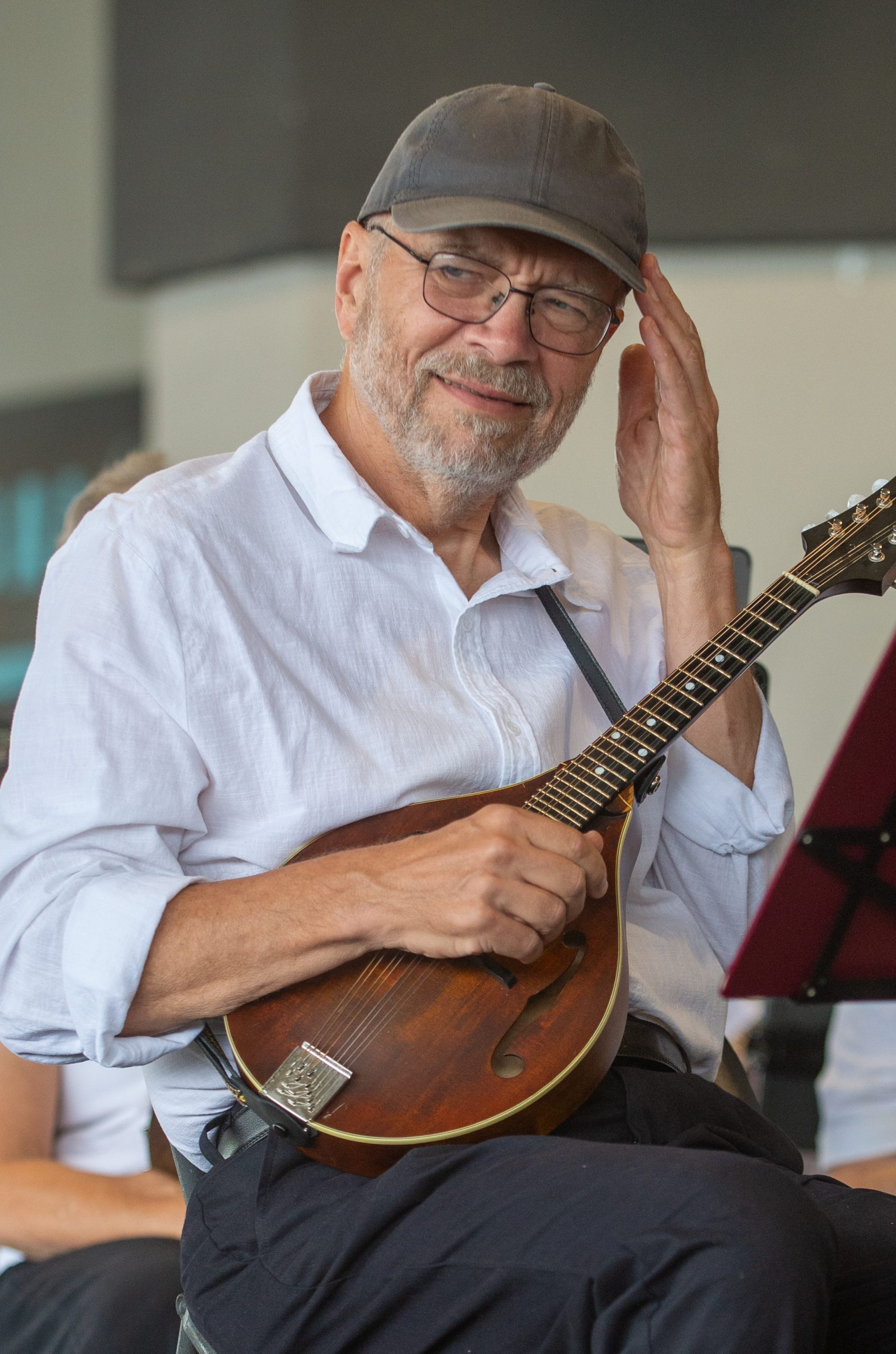 A mandolin player waives to someone in the crowd.